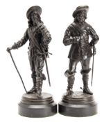 A pair of late 19th/early 20th century bronze cavaliers: in traditional costume each supporting