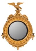A Regency carved giltwood circular convex girandole wall mirror:,