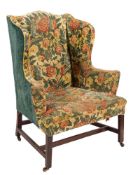 A George III mahogany wing frame armchair:, fully upholstered in floral foliate tapestry,