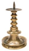A late 17th century brass pricket candlestick: with broad drip tray,