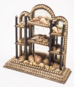 A late 19th century miniature shell display stand: of arched outline,