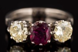A ruby and yellow diamond three-stone ring: with central cushion-shaped ruby approximately 1.