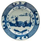 A Chinese porcelain dish: painted in blue with three figures seated beneath a pine tree playing a