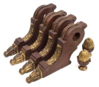 A set of four Regency period mahogany and ormolu mounted curtain pole brackets: of scroll outline