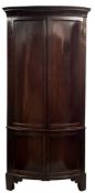 A late 18th/early 19th Century mahogany bow-fronted standing corner cupboard:,