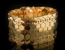 An 18ct gold wide bracelet: of plain and textured honeycomb linking, 36mm wide, 81gms gross weight.