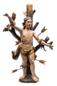 A carved wood and polychrome decorated figure of St Sebastian: the semi-naked figure tied to a