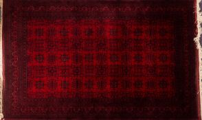 A Turkoman carpet:, of similar design with a main red field, 306cm x 203cm.
