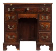 A George III mahogany kneehole desk:, the rectangular top with a moulded edge, fitted with a slide,