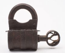 An antique iron lock and key: of barrel shaped outline with turn-screw action, 11cm. high.