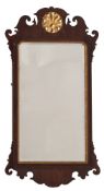 An 18th Century walnut and partly gilt fret carved mirror:, with gilt palmette roundel cresting,