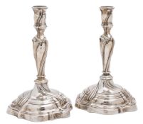 A pair of German silver candlesticks: of wrythen form with urn-shaped nozzles on knopped stems and