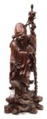 A large Chinese carved hardwood figure of Shou Lao: the smiling Immortal holding a knarled staff