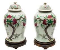 A pair of large Chinese famille rose 'peach' vases and covers: of baluster form with domed covers,