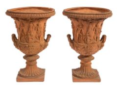 A pair of terracotta twin-handled garden urns:, of campagna shape with beaded and reeded edges,