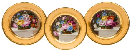 A set of three Paris porcelain plates: each painted with a basket of flowers on a marble table