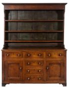 A late 18th Century oak dresser:, the shelved superstructure with a moulded cornice,