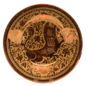 An Hispano Moresque copper lustre pottery deep dish: painted with a stylised lion on a ground of
