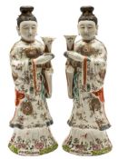 A pair of Chinese famille rose figures: of court ladies holding Gu-shaped vases,