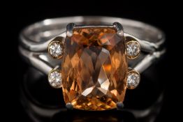 A modern topaz and diamond ring: the cushion shaped topaz approximately 10.7mm long x 8.