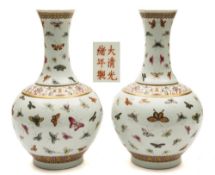 A pair of Chinese famille rose 'hundred butterfly' bottle vases: painted overall with colourful