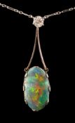A black opal and diamond mounted lavalier: the oval black opal approximately 18mm long x 10mm wide