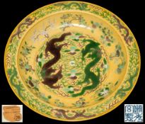 A large Chinese yellow ground 'dragon' charger with Chuxiugong mark: incised and painted in green,