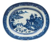 A Chinese export blue and white oval meat dish: painted with an extensive lake scene with pagodas