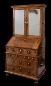 A William and Mary walnut veneer and feather banded bureau cabinet:, in three sections,