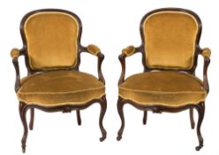A pair of Victorian carved rosewood armchairs in the Louis XV taste:,