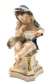A Meissen figure of a putto emblematic of Winter: wearing a blue fur lined cloak and holding a pan