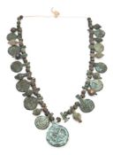 A group of Byzantine bronze amulets and beads: 5th-7th century, threaded on a cord.