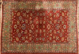 A Persian carpet:, the rust field with an all over design of palmettes and stylised floral foliage,