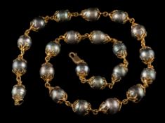A caged cultured black baroque pearl,