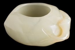 A Chinese carved jade brush washer: in the form of a flattened peach with stalk to one side,