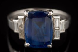 A sapphire and diamond ring: the rectangular sapphire in four-claw setting approximately 10.