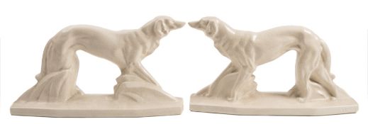 A pair of French Art Deco pottery figures of Borzois: each standing in alert pose on elongated