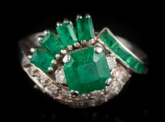 An emerald and diamond cluster ring: the central,