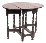 An early 18th Century oak oval gateleg table:, the hinged top on bobbin turned legs,