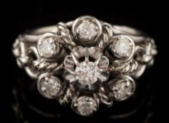 A French platinum and diamond seven-stone cluster ring: of pierced,
