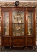 An Edwardian mahogany and inlaid serpentine fronted display cabinet:, bordered with boxwood lines,