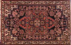 A Qashgai rug:, the shaded field with a brick red pointed medallion and geometric designs,