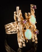 An opal and ruby mounted informal cluster ring: of textured finish,