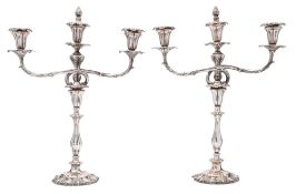 A pair of Victorian silver plated twin-branch candelabra: the urn shaped nozzles with foliate