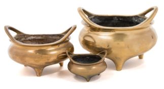 A Chinese bronze tripod censer: of squat circular form, with swept handles,