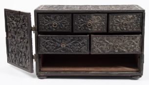 An Eastern carved ebony table top cabinet: of rectangular outline,