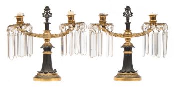 A pair of Regency period gilt bronze twin-branch table lights: with urn-shaped nozzles,