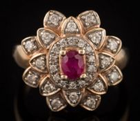 An 9ct gold, ruby and diamond oval cluster ring: with central oval ruby approximately 5mm x 4mm,