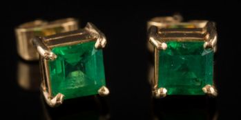 A pair of square emerald single-stone ear-studs: each with a square-cut emerald approximately 5mm