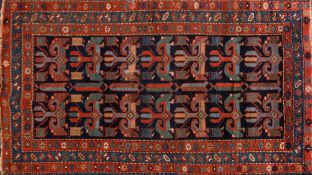 A Kurdish fertility rug:, the indigo field with two rows of hooked geometric medallions,